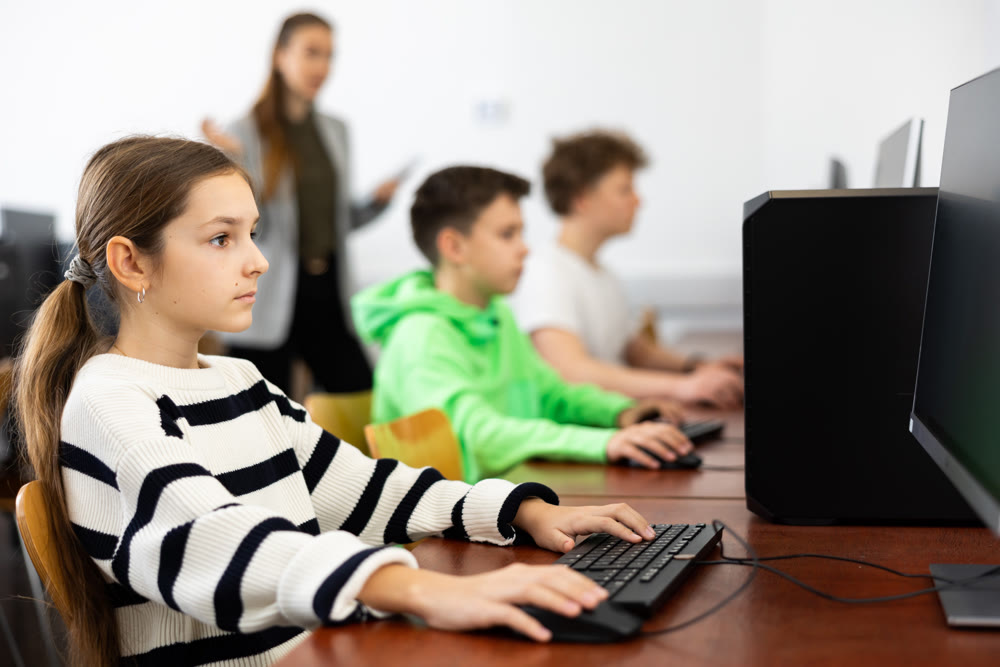 Focused teenage girl studying in college computer lab