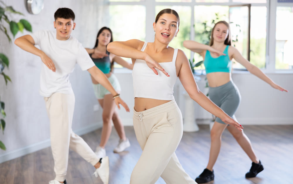 Girl teen perform choreographic exercise and teach energetic waacking dance with friends