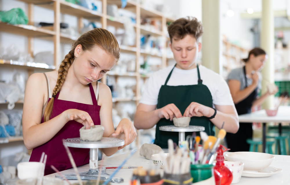 Teenagers are interested in making dishes from clay in pottery workshop