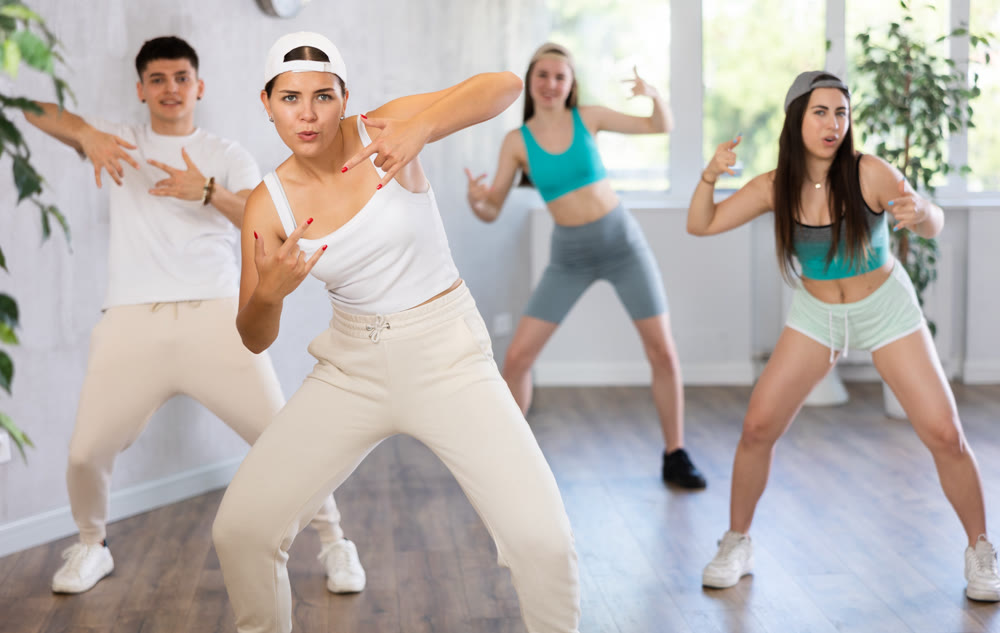 Girl teen perform choreographic exercise and teach energetic mobile social dance vogue with friends