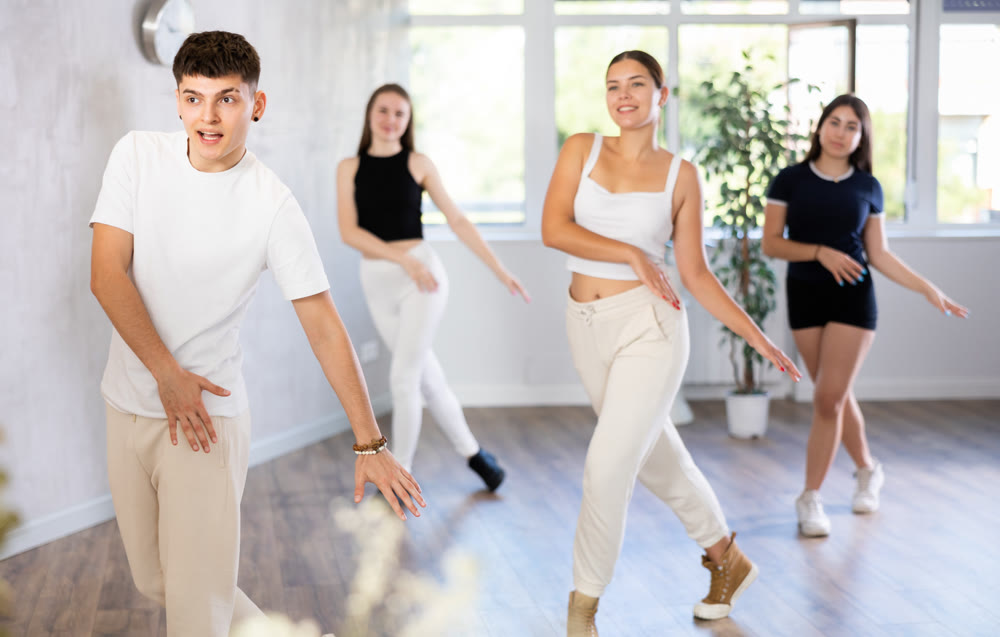 Group of young women and young guy dance contemporary
