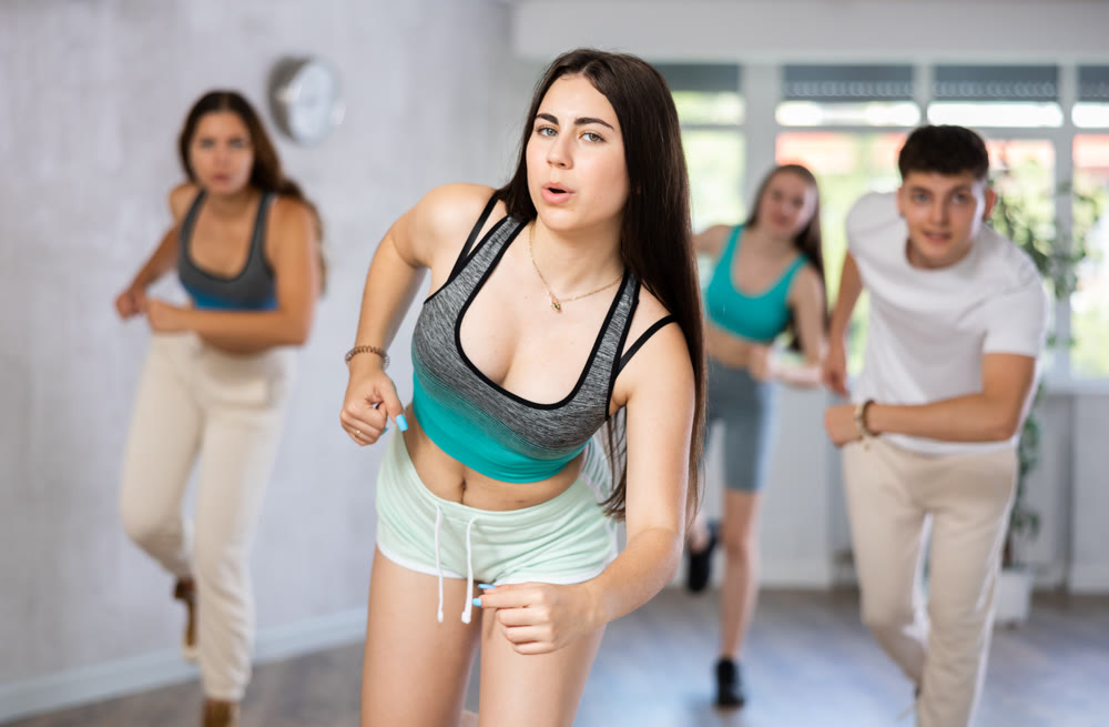 Teenagers boys and girls performing hip hop in studio