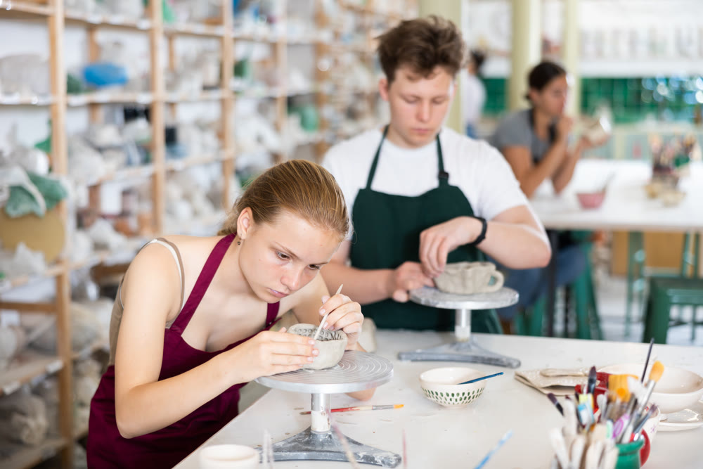 Teenage girl and teenage boy sculpt ceramic product