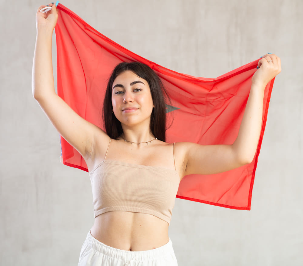 Young woman with flag of Morocco posing in studio