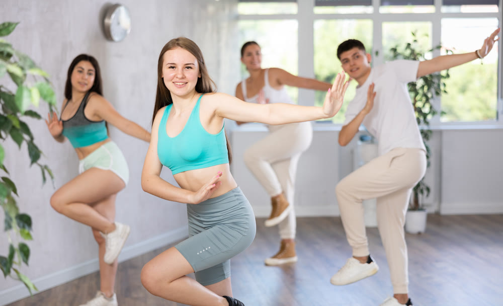 Girl teen perform choreographic exercise and teach energetic waacking dance with friends