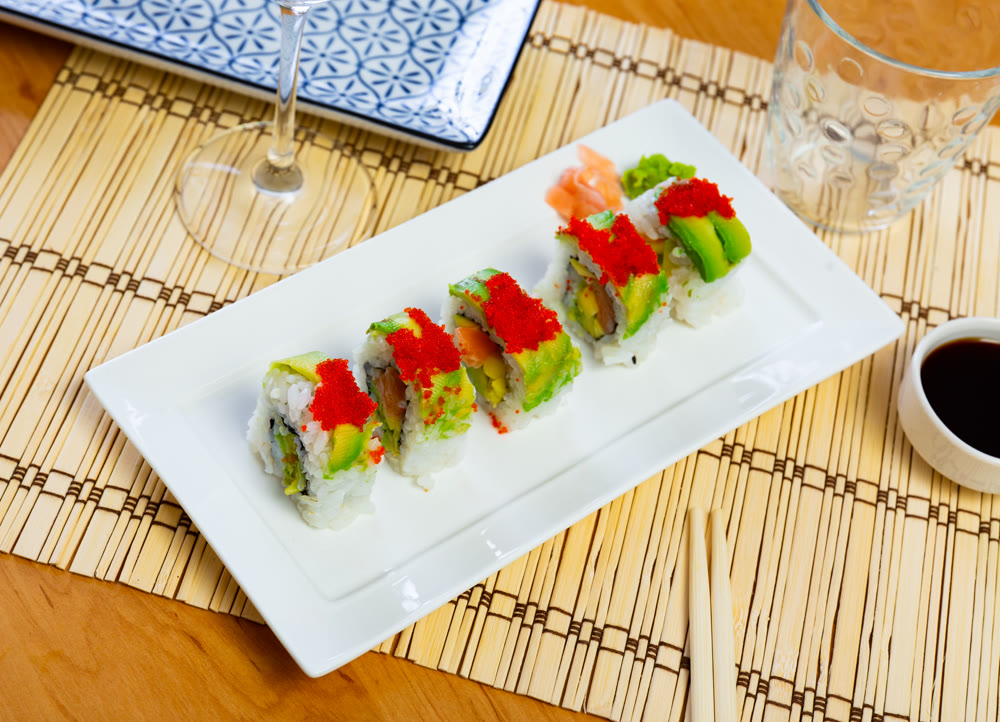 Uramaki - Dragon sushi roll with salmon and mango, tropical flavor.