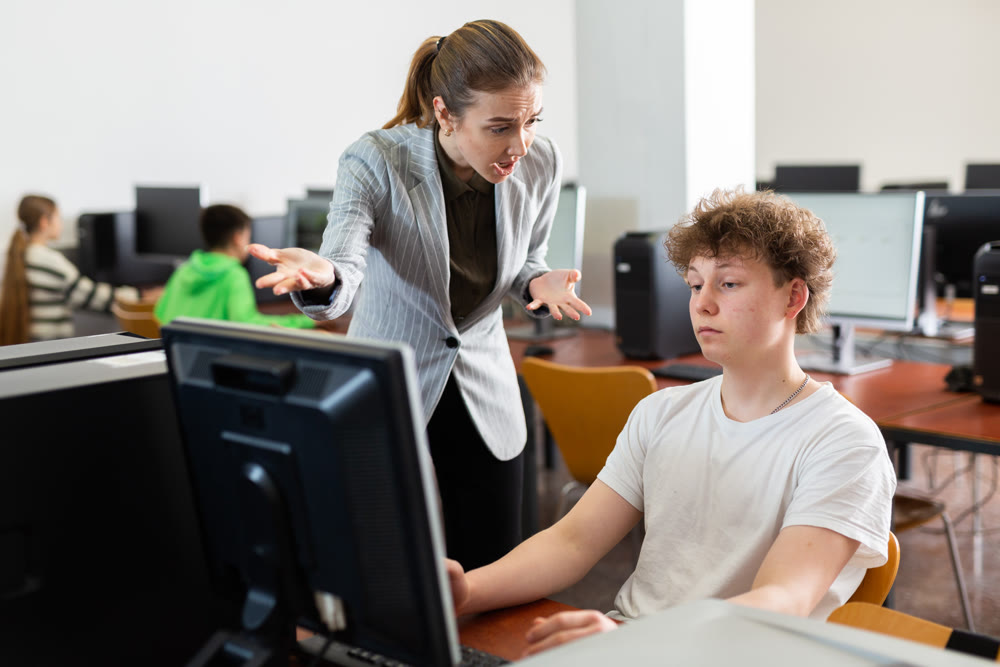 Teacher shouting at teenage boy during lesson