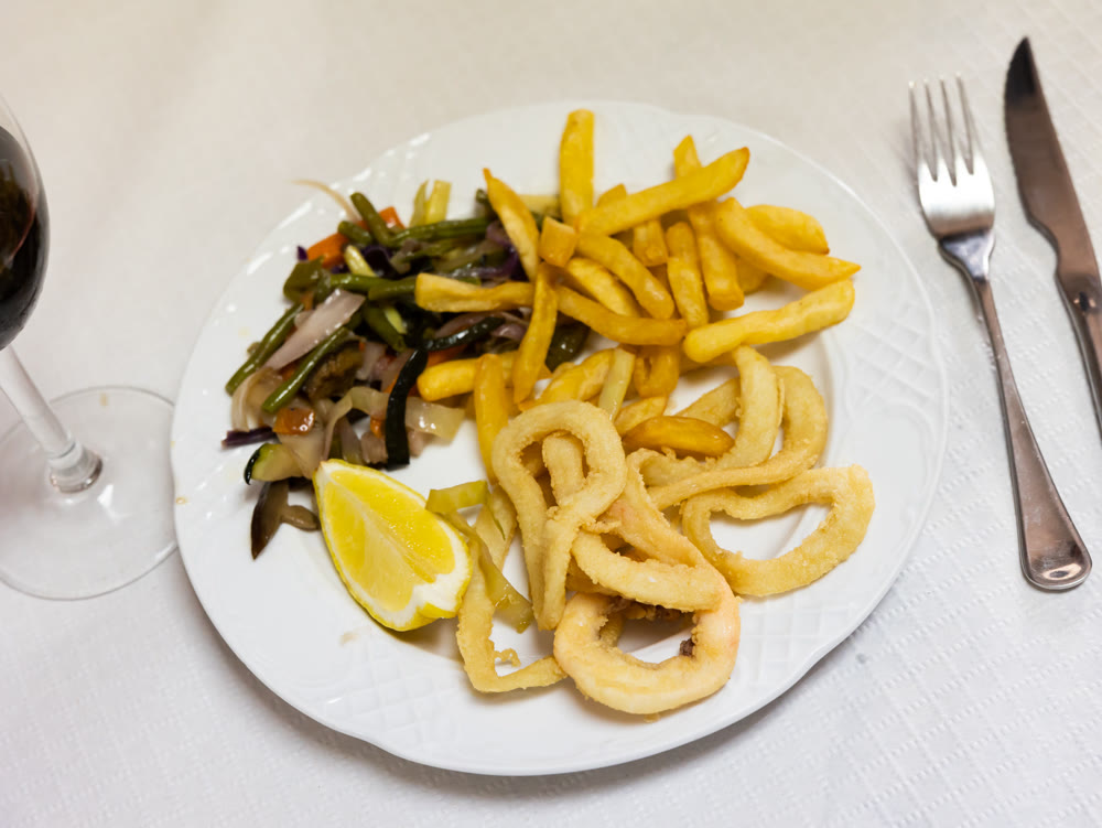 Deep-fried coated squid rings with fries and sauteed vegetables