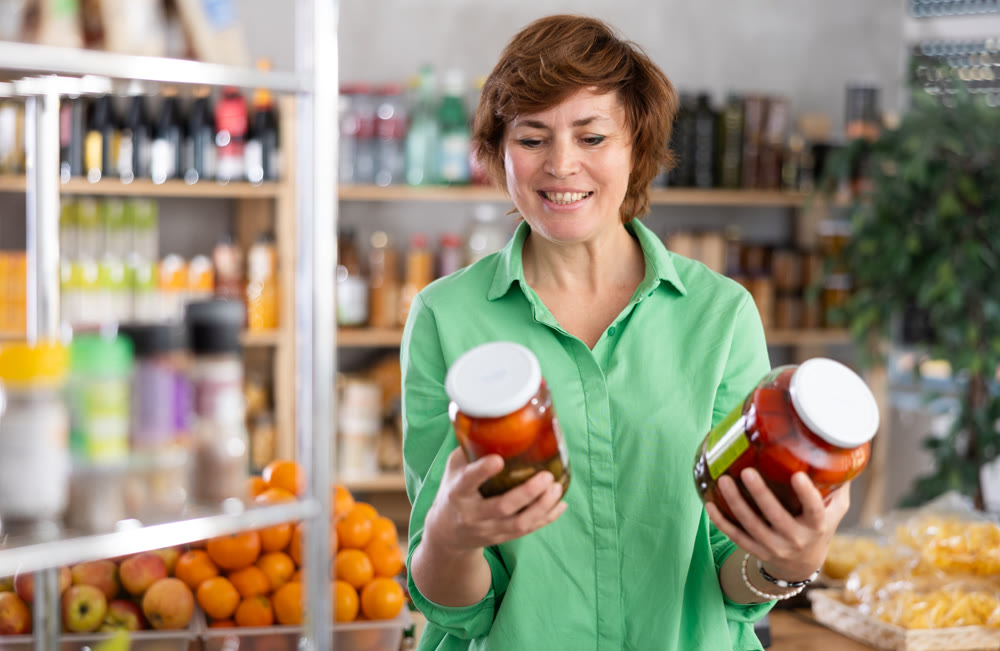 Woman chooses tomatoes in marinade