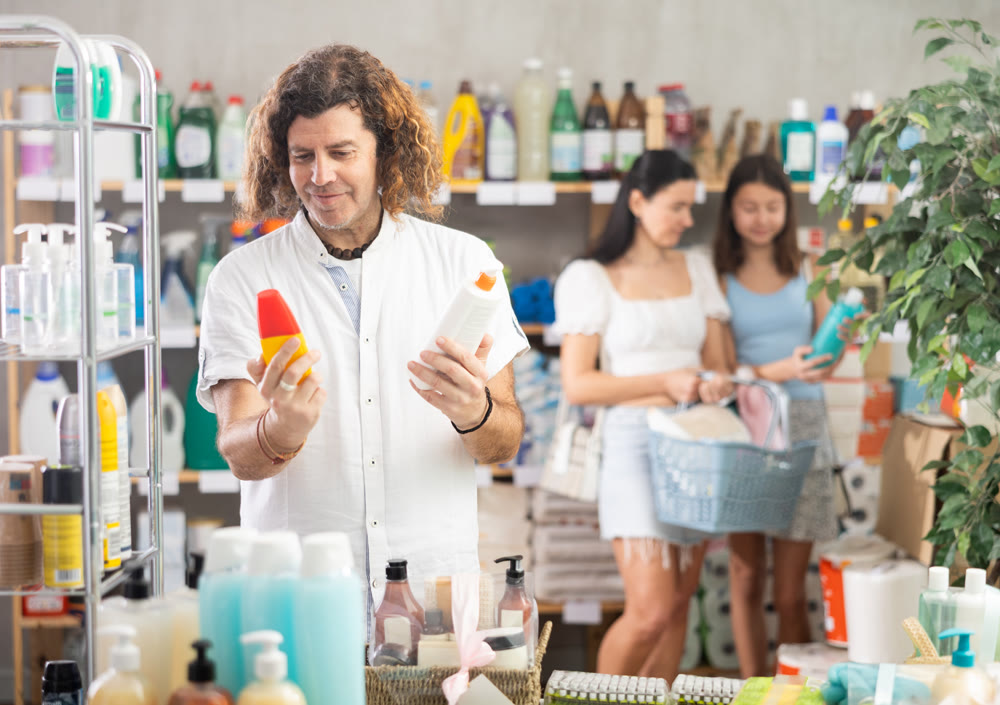 Dad choosing sunscreen for summer family vacation in store