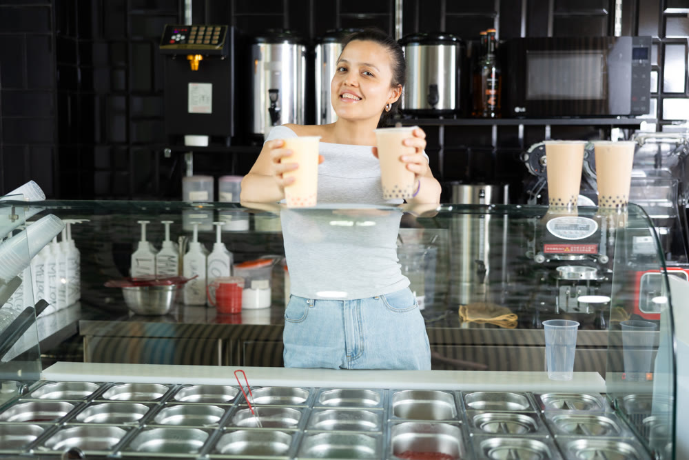 Girl supermarket employee offers to drink bubble tea