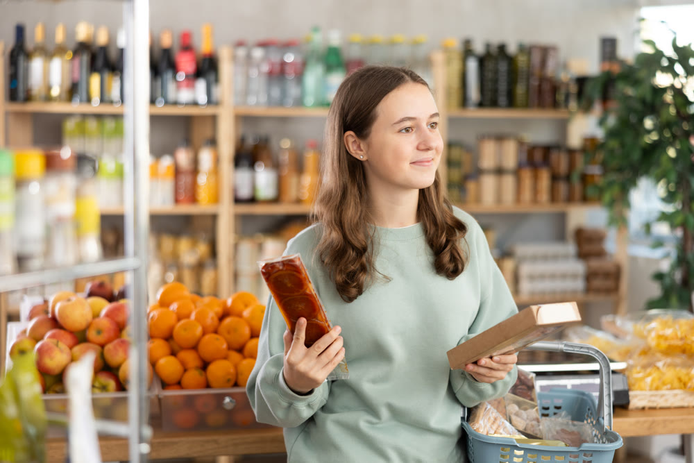 Teen girl selects suitable product from nougat assortment