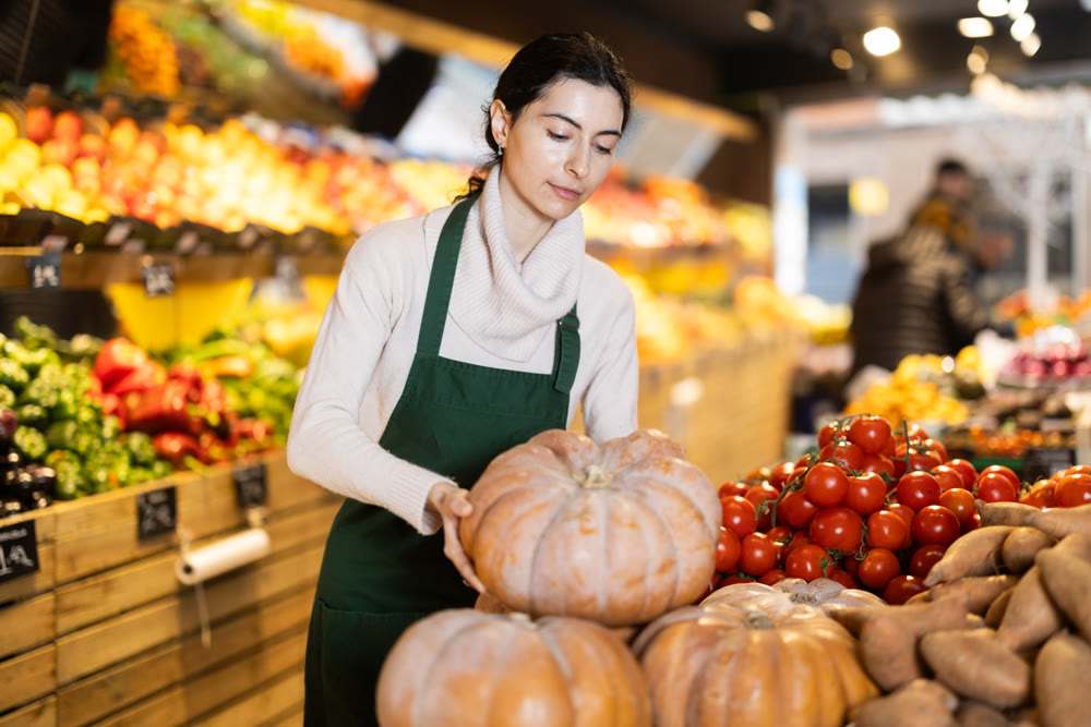 Woman seller checking pumpkin