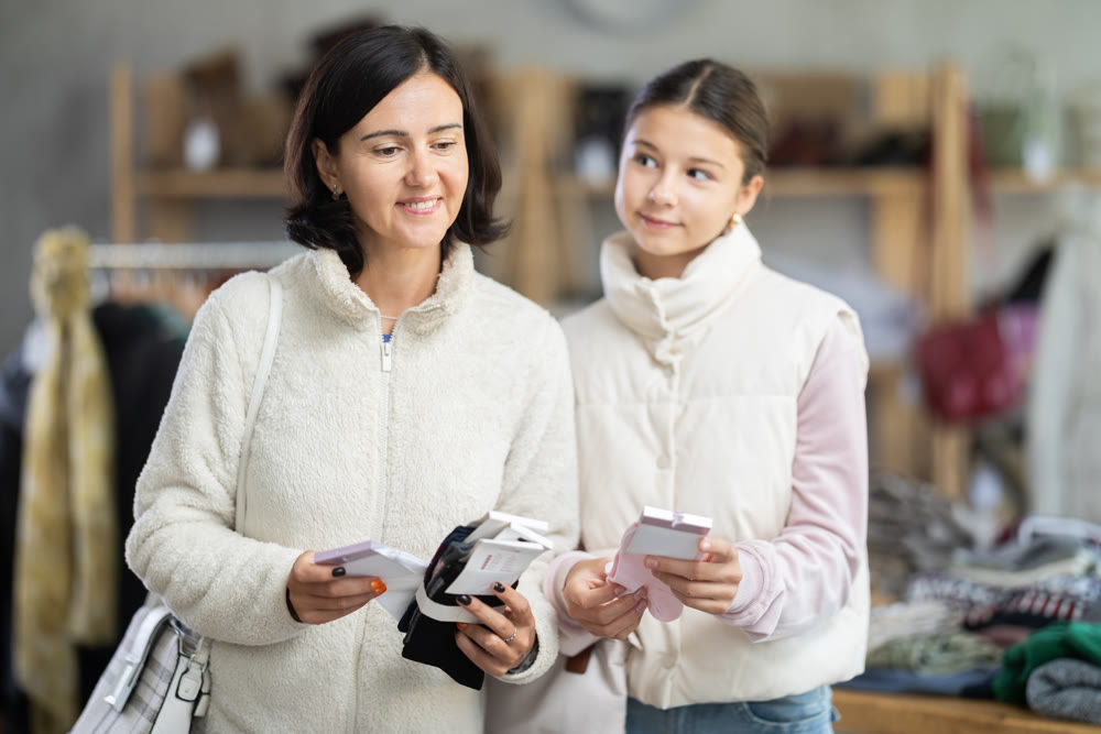 Mother and teen daughter looks at products in store and selects cotton socks.