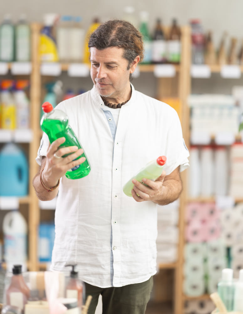 Adult man chooses dishwashing detergent in store