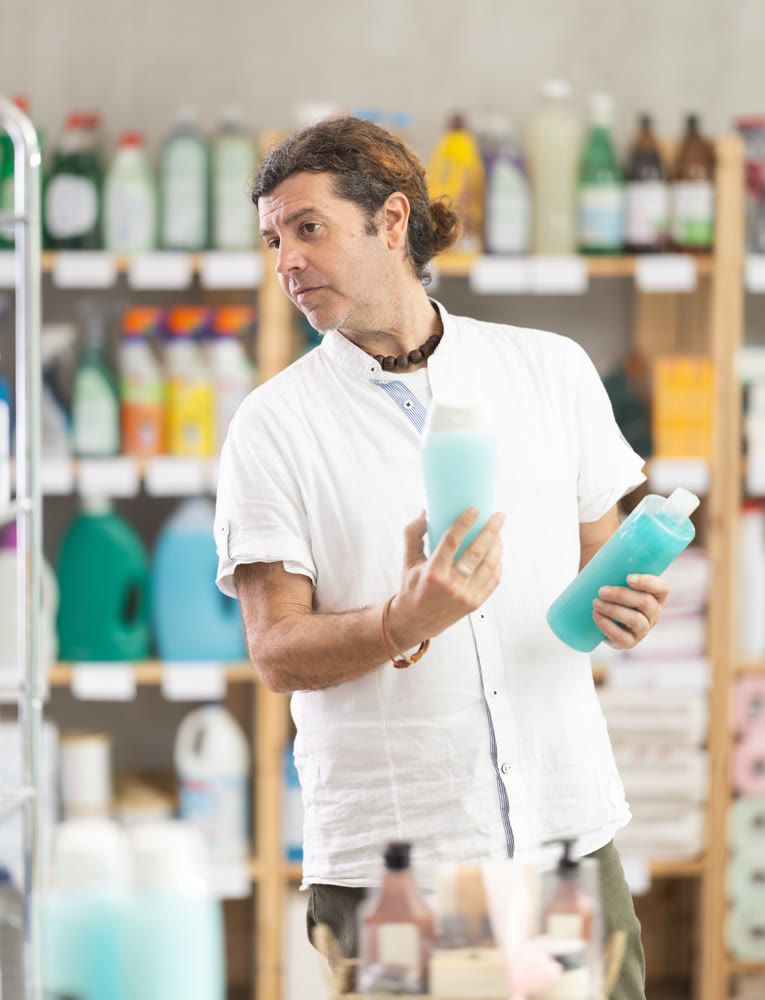Man choose product and doubts, faultfinding buyer pick shower gel for allergy sufferers