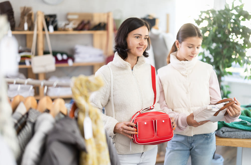 Adult woman and teenage girl choose handbag