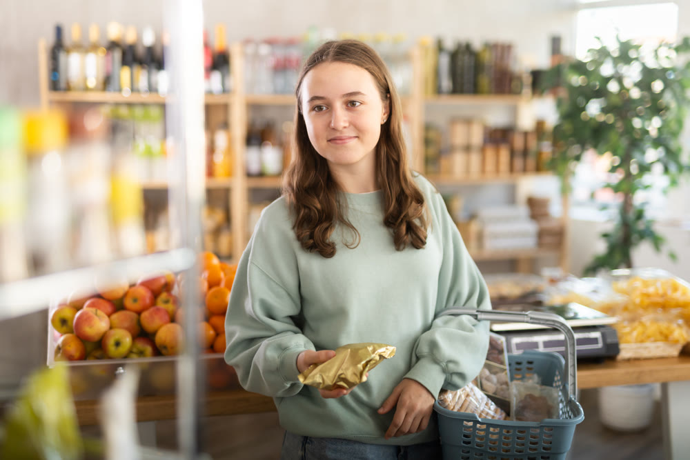 Teenage girl choosing food in grocery store