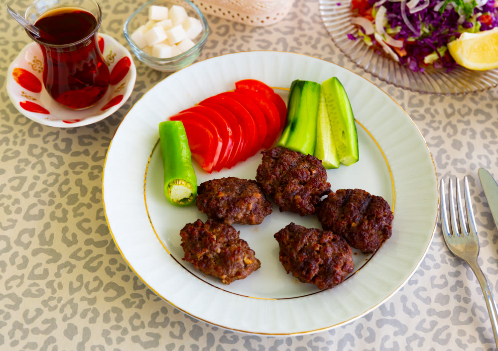 Fresh Turkish kofte served with sliced vegetables