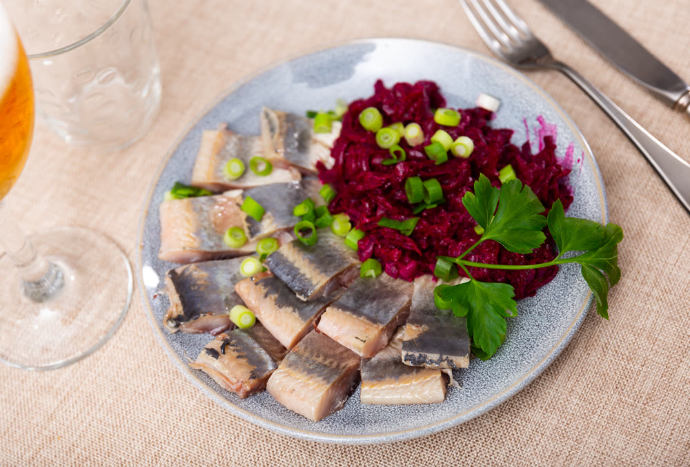 Nicely served sliced salted herring with beet salad on side