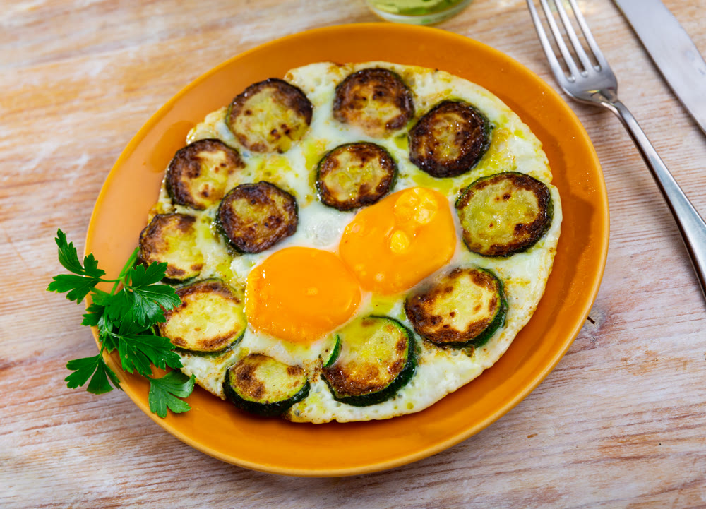 Fried eggs with zucchini and herbs