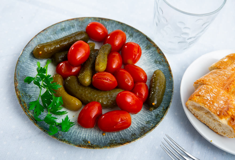Homemade marinated tomatoes and cucumbers on plate
