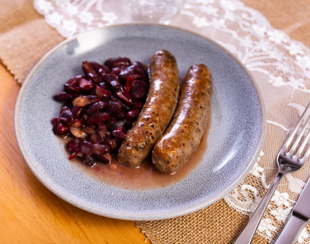 Hot delicious sausages with beans and parsley on plate