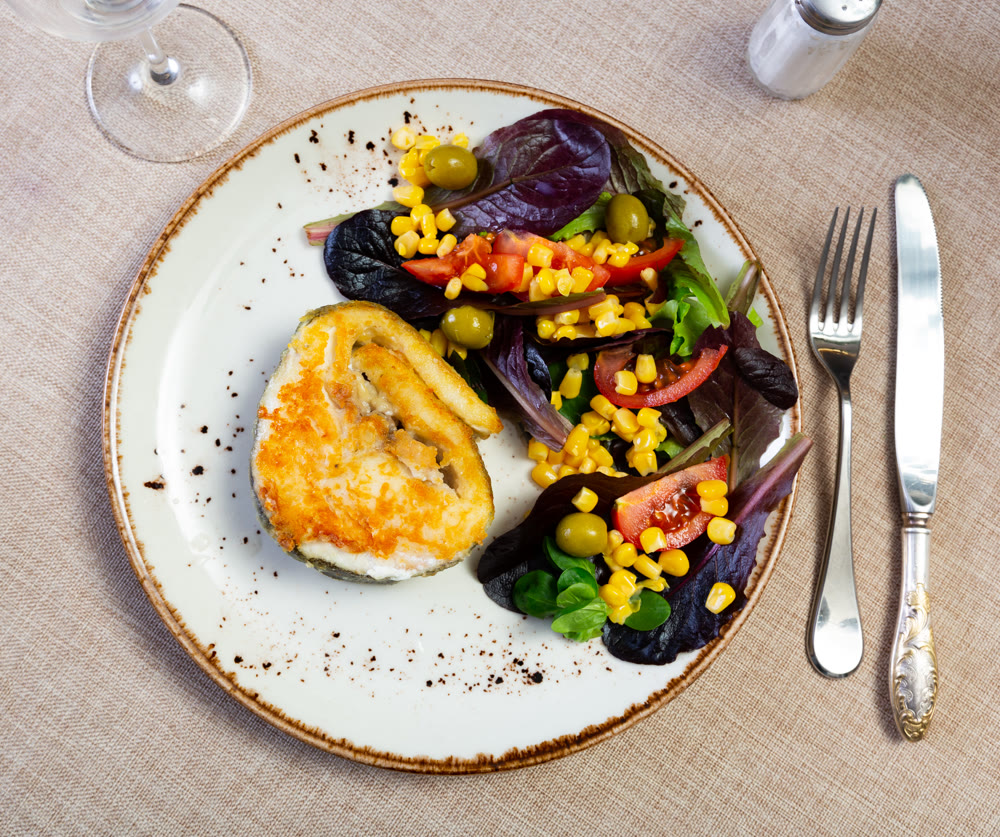 Bacalhau fillet served with fresh vegetable salad