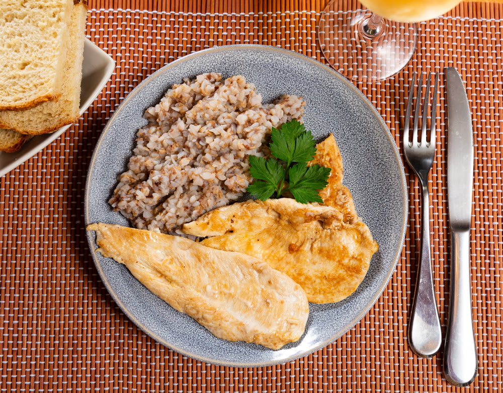 Delicious roasted turkey breast with buckwheat porridge on table