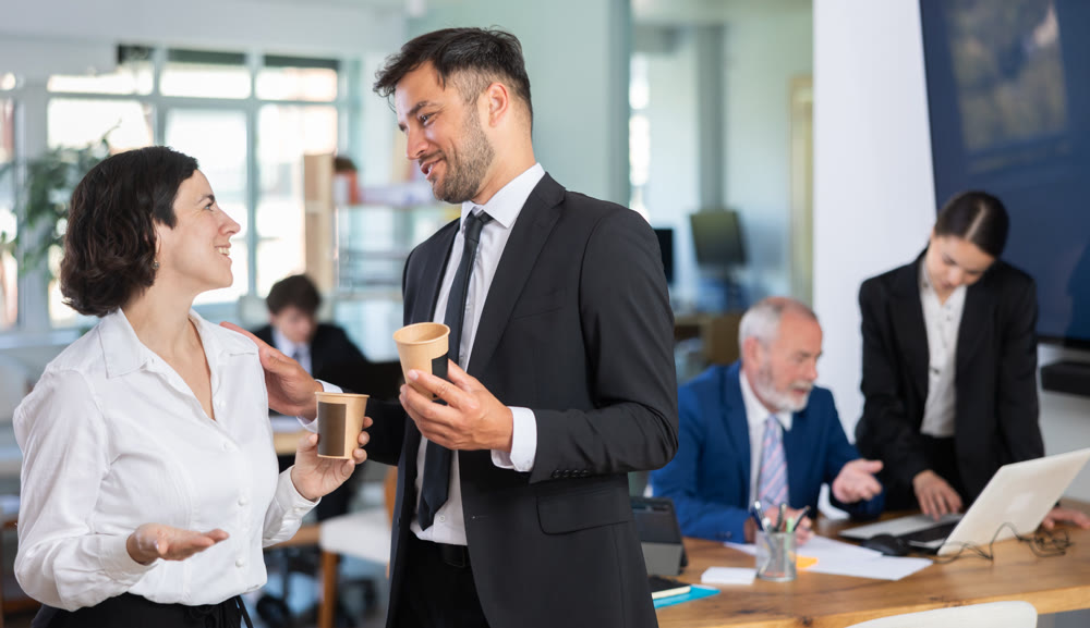 Man and a woman with hot drinks at work