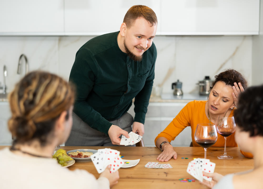 Two married couples playing card game poker