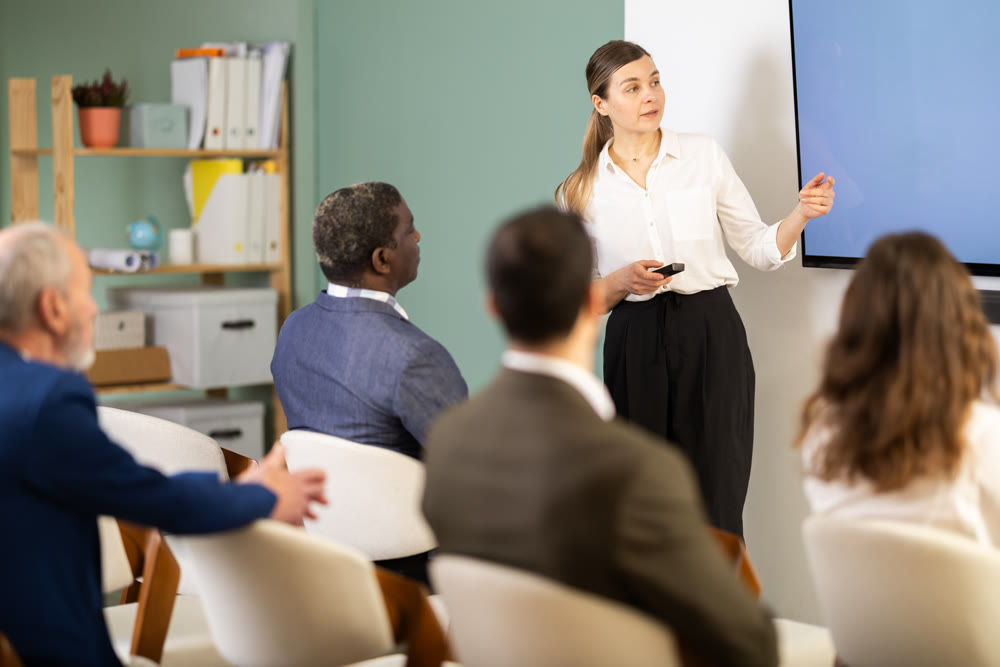 female speaker giving a lecture in front of a group of people