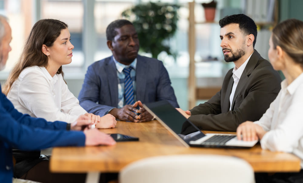 Group of businessmen and businesswomen holding meeting at table