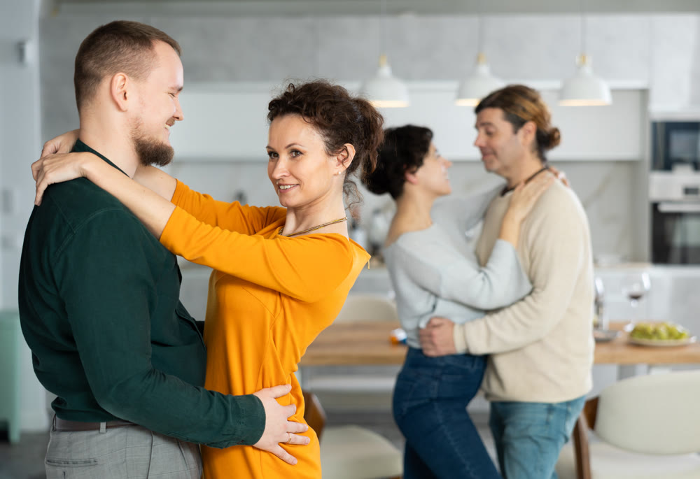 Men and women dancing during house party.