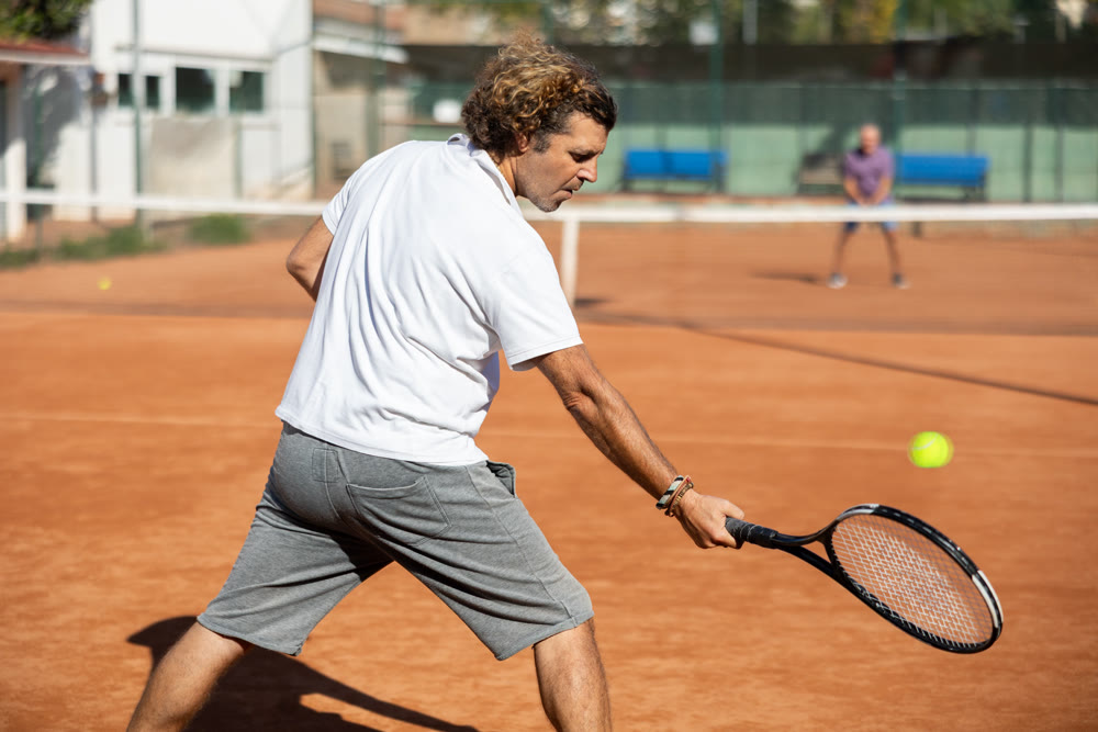 man playing tennis in the city court