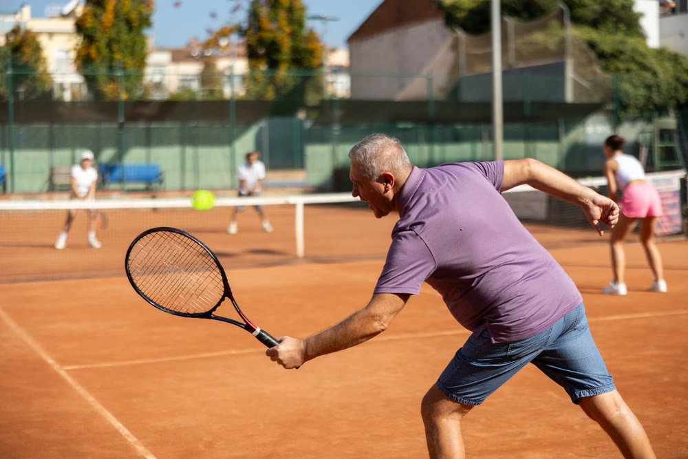 Elderly man playing tennis