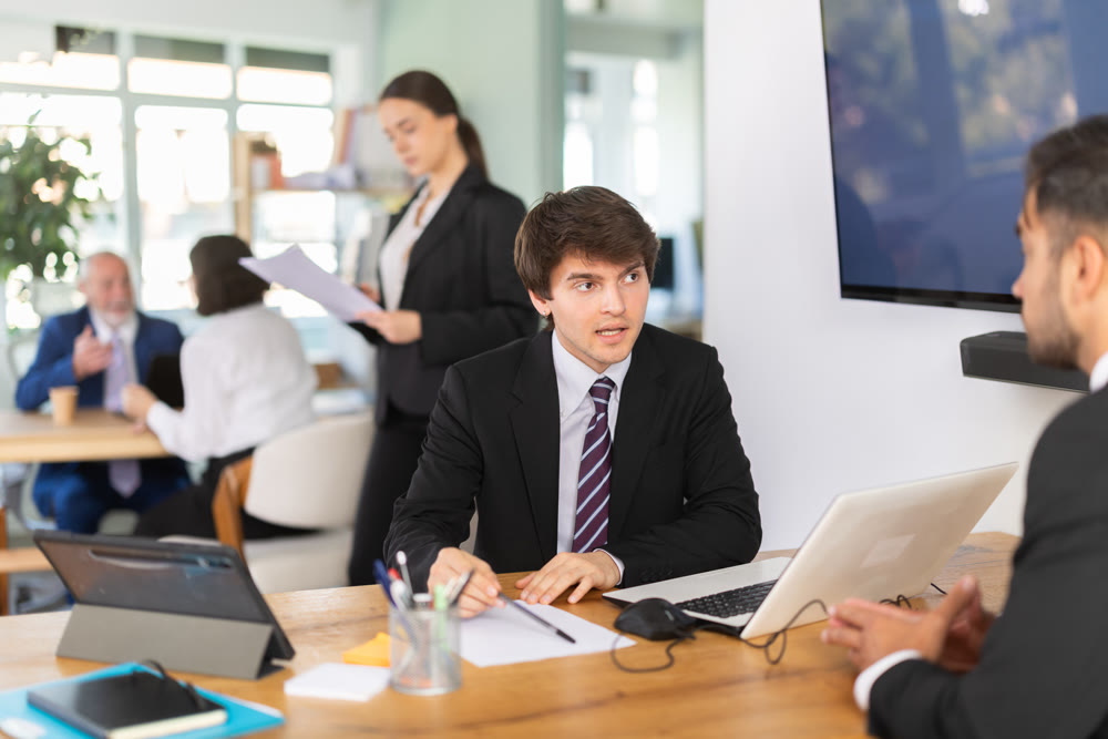 Consultant of a modern bank office tells a man about deposits and savings accounts