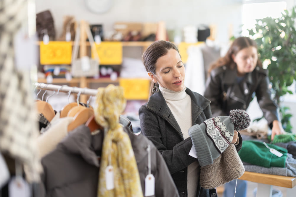 Adult woman choosing hat in clothing store