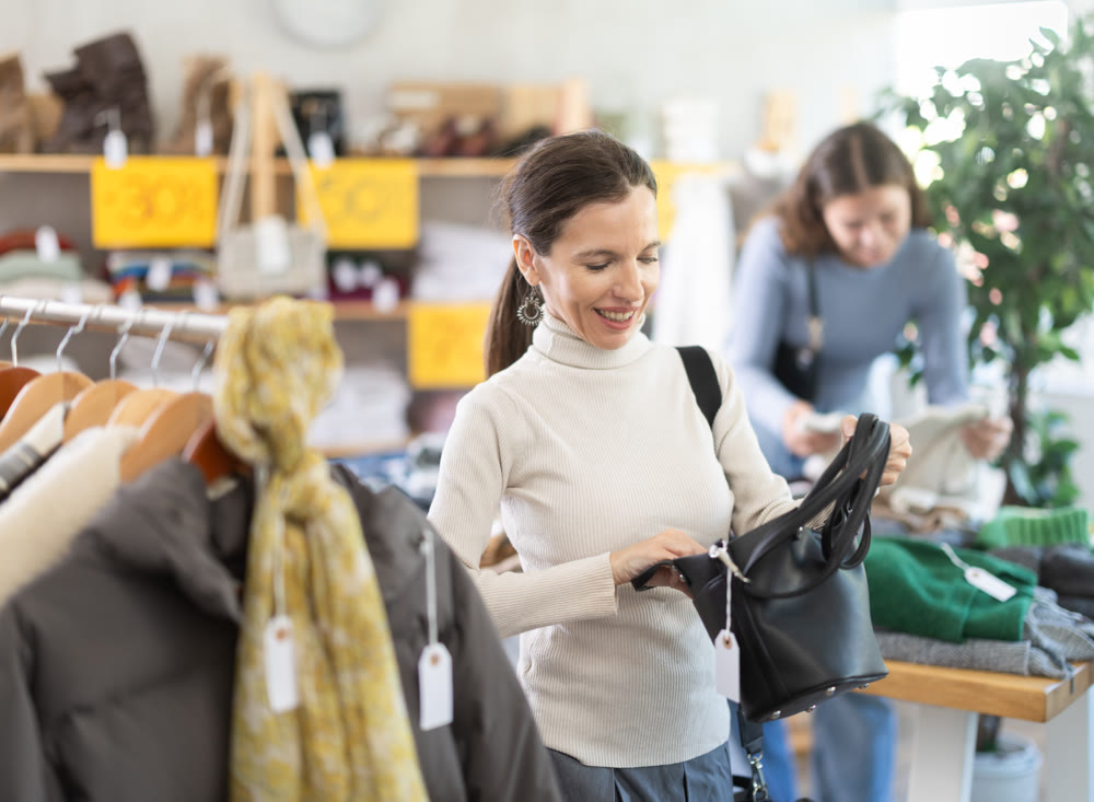Woman chooses fashionable handbag in clothing boutique