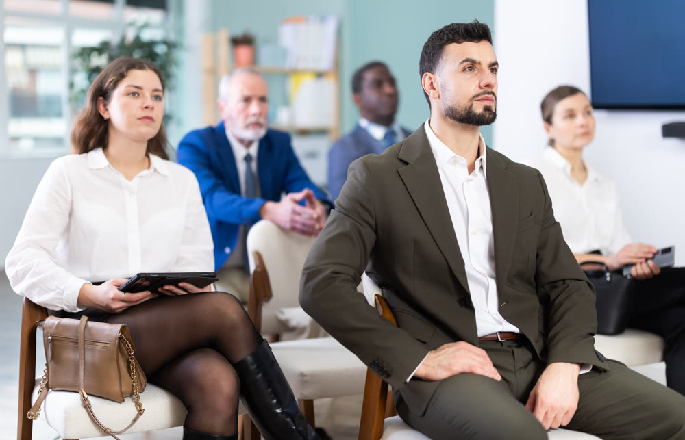 During lecture meeting, adult pupils listen and look to teacher
