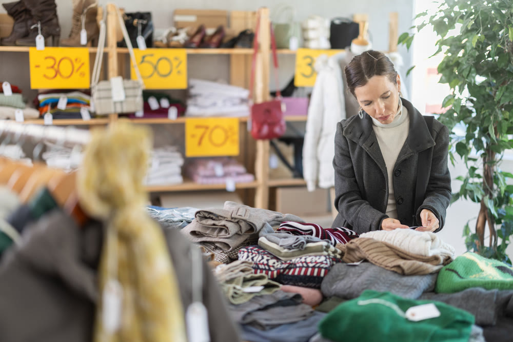 Adult woman chooses sweater in clothing store