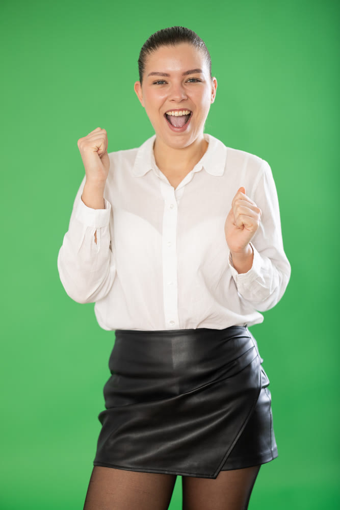 European woman stands against a green background