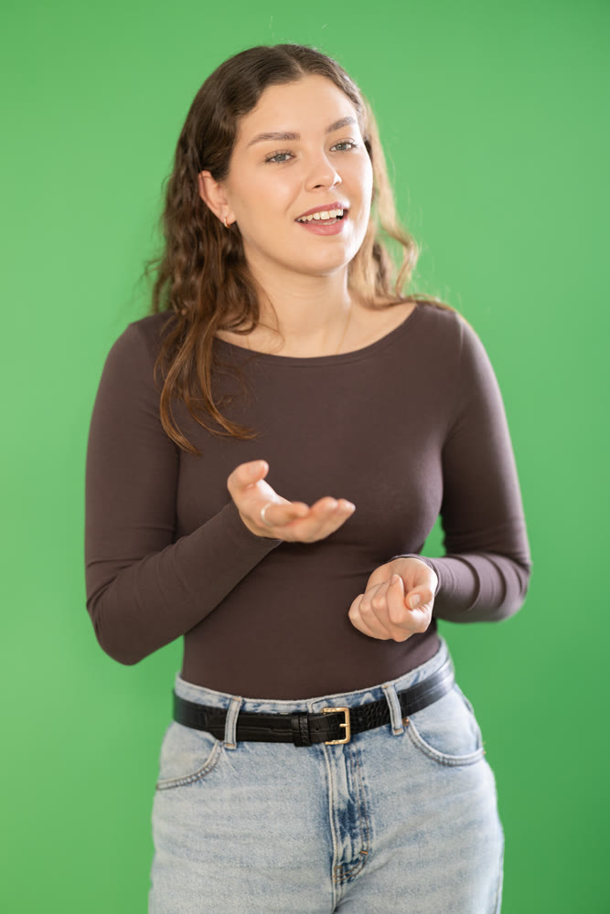 Smiling girl is talking to someone and posing on green screen. Chroma key compositing.