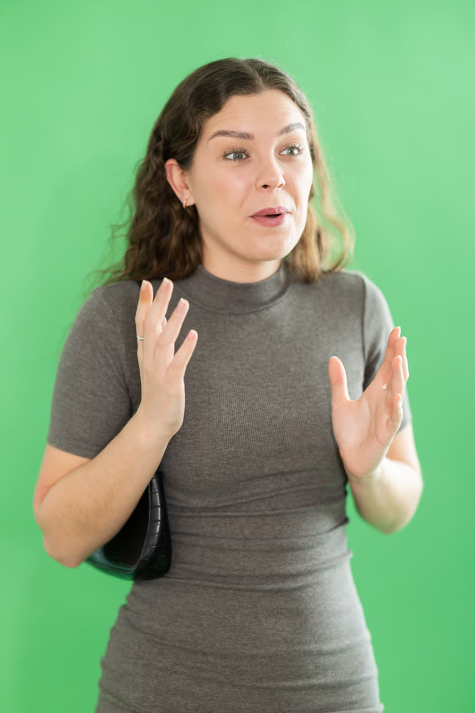 Young woman happy and smiling in front of green screen