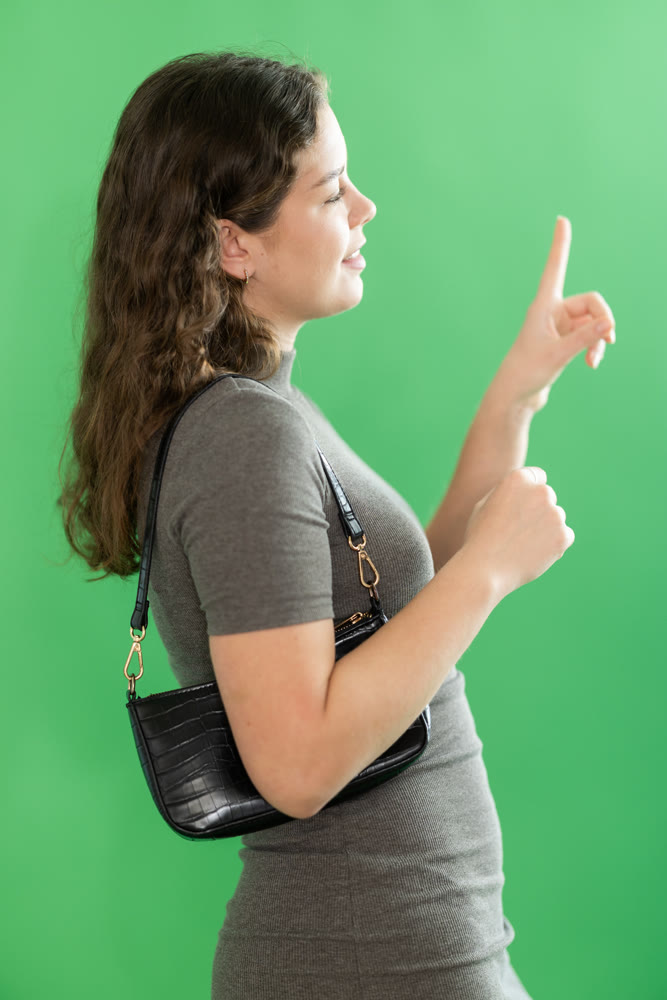 Young woman using virtual screen in front of green screen