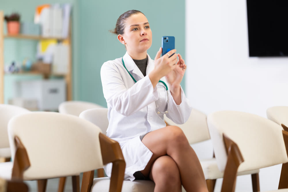 Young female student taking a photo of a lecture on mobile