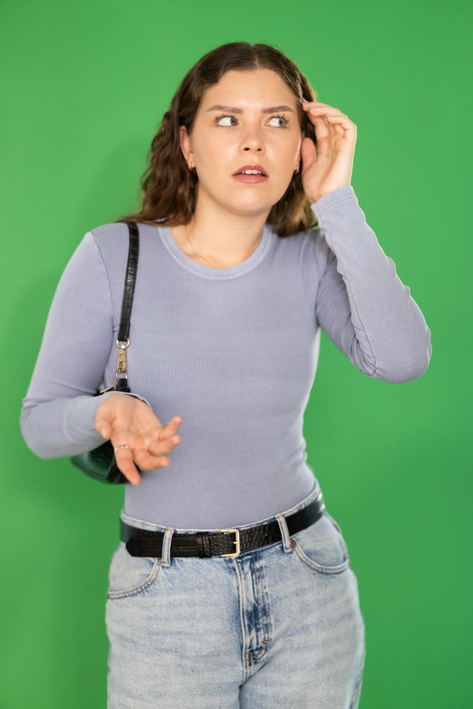 Young woman confused and forgetful in front of green screen