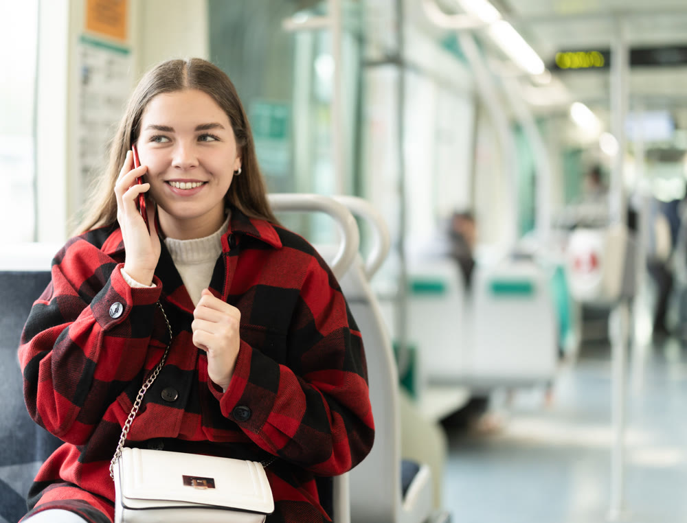Girl sit in tram car and emotionally talks on phone, getting to work