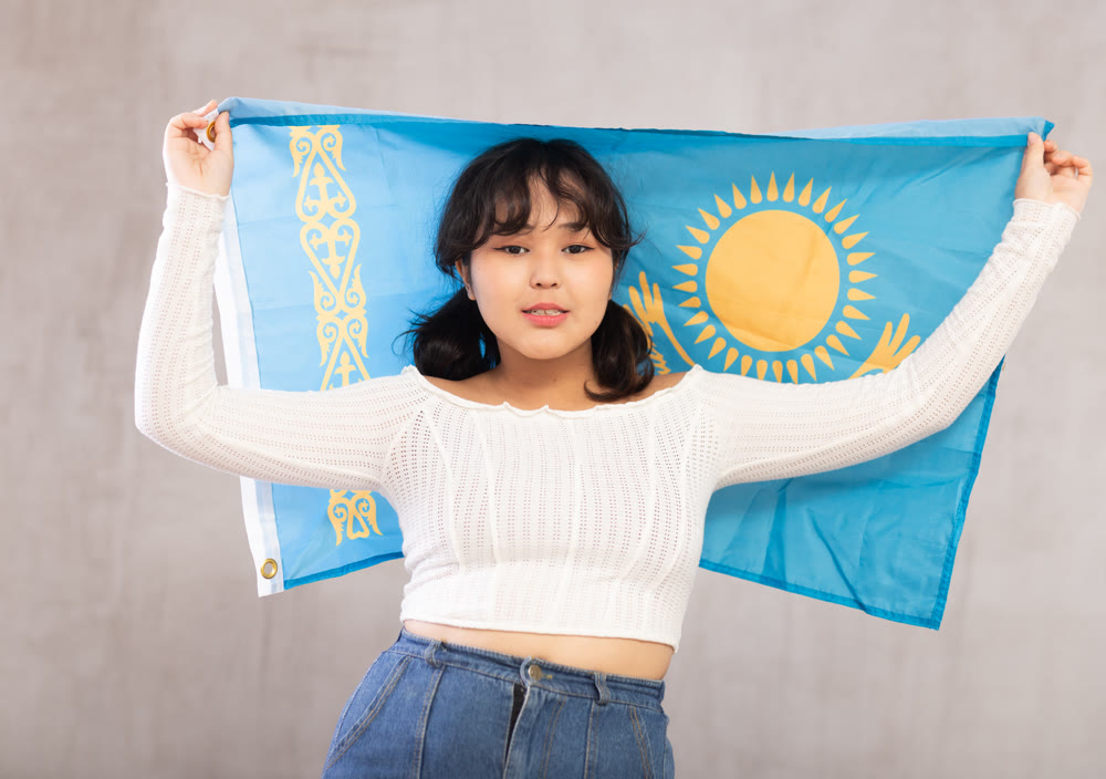 Displeased young girl holding flag of Kazakhstan