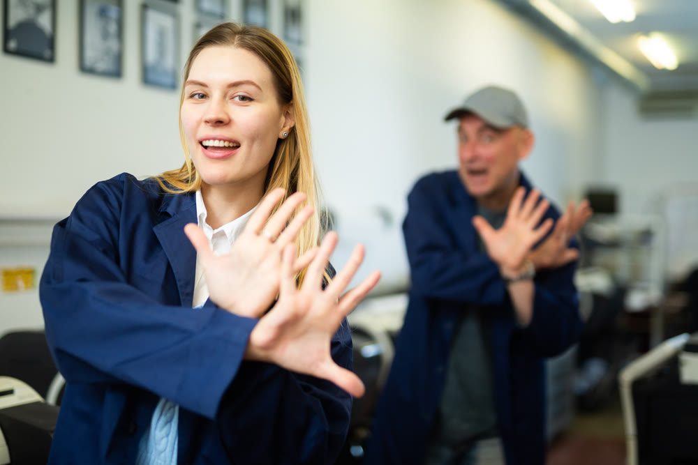Woman and man dancing funny dance in printshop